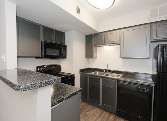 a kitchen with granite countertops and black appliances