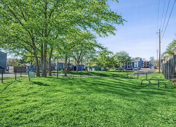 A park with a green lawn and trees.