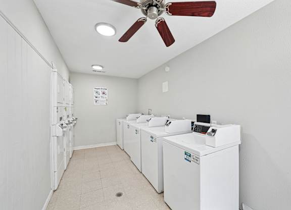 A laundry room with a fan and washing machines.
