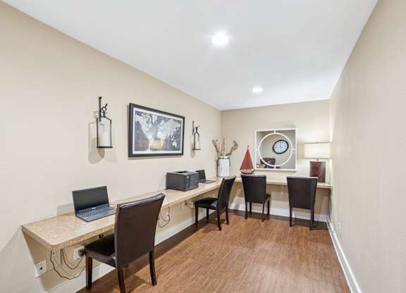 A room with a desk and chairs.