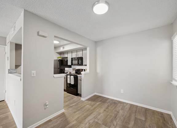 A kitchen area with a refrigerator, sink, and cabinets.