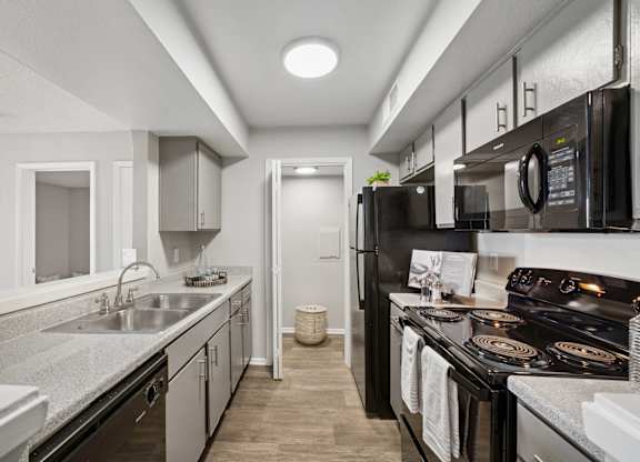 A modern kitchen with black appliances and white cabinetry.