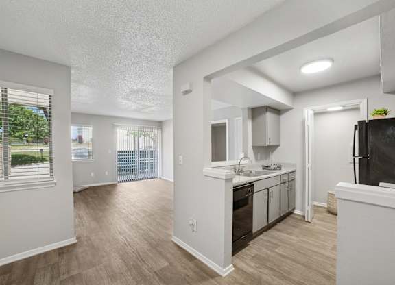 A kitchen with white cabinets and a black fridge.