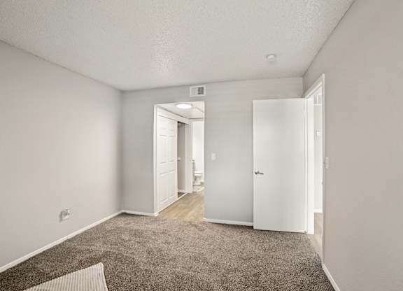 A room with a carpeted floor and white walls.