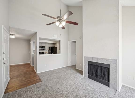 A living room with a fireplace and a ceiling fan.