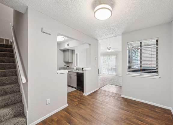 A kitchen area with a staircase on the left side.