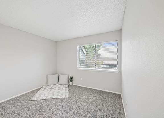 A bedroom with a window and a bed.