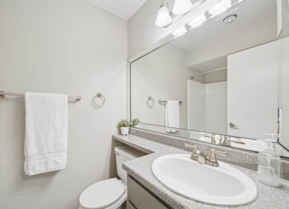 A white towel hangs on a towel rack in a bathroom.