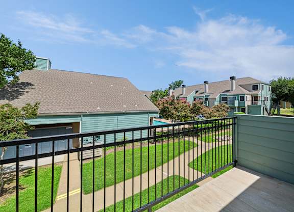 A house with a green roof and a black fence.