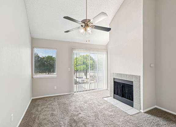 A room with a fireplace and a ceiling fan.