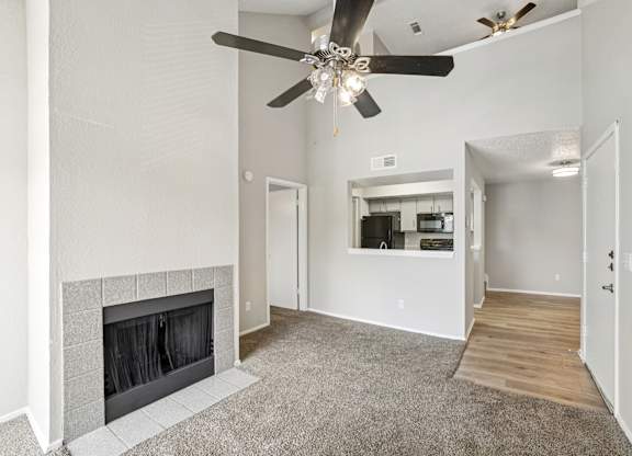 A living room with a fireplace and a ceiling fan.