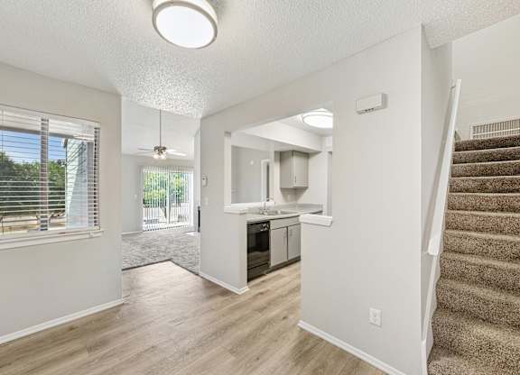 A spacious living room with a staircase leading to the upper floor.