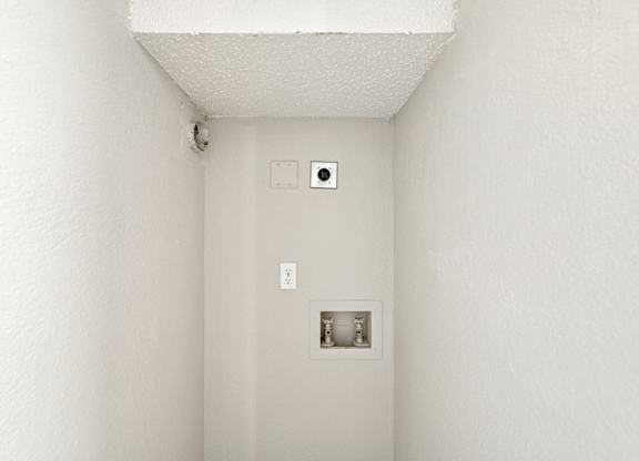 A white wall with a switch and a socket.