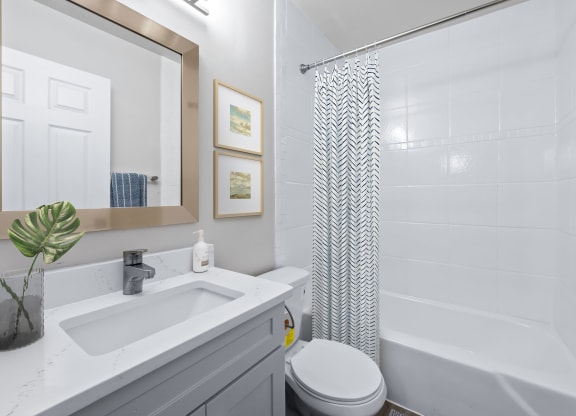 a bathroom with a white sink and toilet next to a white bathtub with a shower curtain  at Sunset Heights, Texas