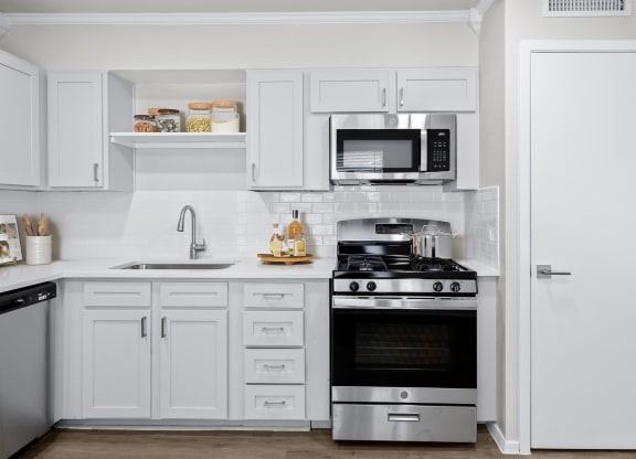 a kitchen with white cabinets and stainless steel appliances  at Sunset Heights, San Antonio