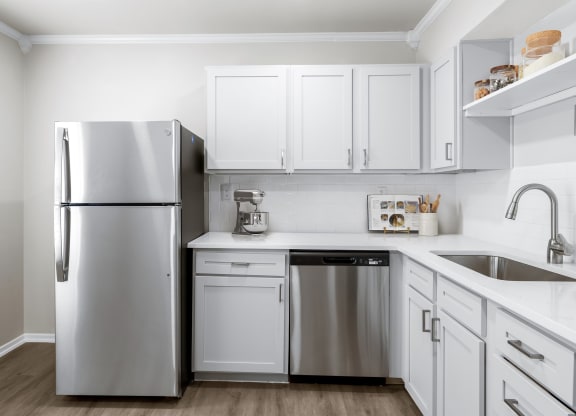 a kitchen with white cabinets and stainless steel appliances  at Sunset Heights, Texas