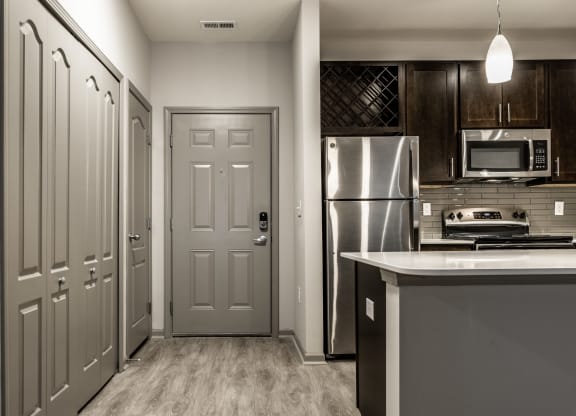 a kitchen with stainless steel appliances and a grey door Fisher, Indiana