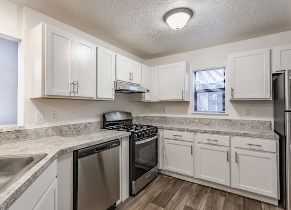 A kitchen with white cabinets and stainless steel appliances at Huntington Cove Apartments, Merrillville, IN, 46410