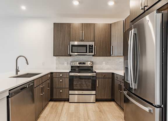 A modern kitchen with stainless steel appliances and wooden cabinets at Upper Vue Flats, Dublin