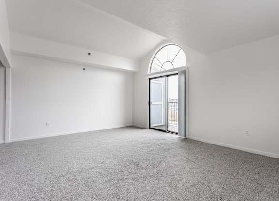 A room with a carpeted floor and a large arched window at Huntington Cove Apartments, Merrillville, IN, 46410