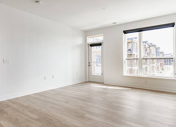 A large empty room with a view of a cityscape through the window at Upper Vue Flats, Dublin
