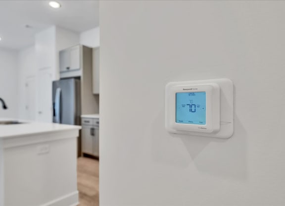 a white kitchen with an electric thermostat on the wall at Luxe 360 on Centerpointe Apartments, Virginia, 23114