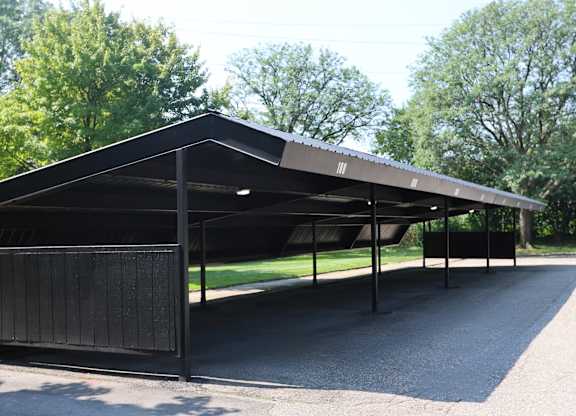 A black carport with a metal roof and a metal fence