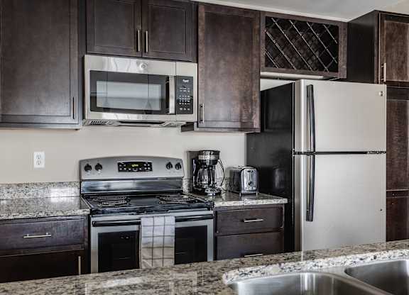 A kitchen with a stove, oven, microwave, and refrigerator.