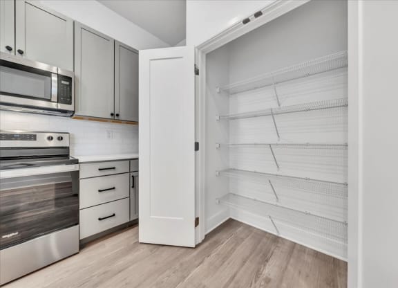 a kitchen with white cabinets and a large white closet at Luxe 360 on Centerpointe Apartments, Virginia