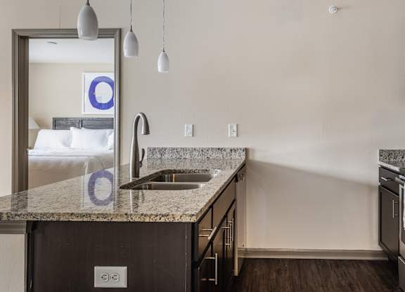 A kitchen with a granite countertop and stainless steel appliances.