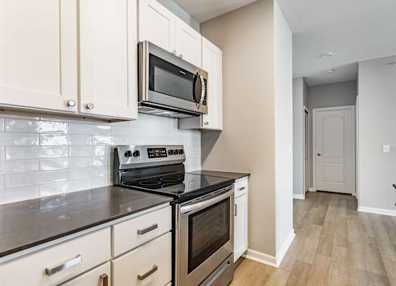 A kitchen with a stove top oven and microwave above it.