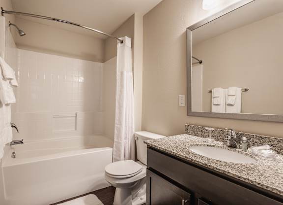 A white bathroom with a toilet, sink, and bathtub.
