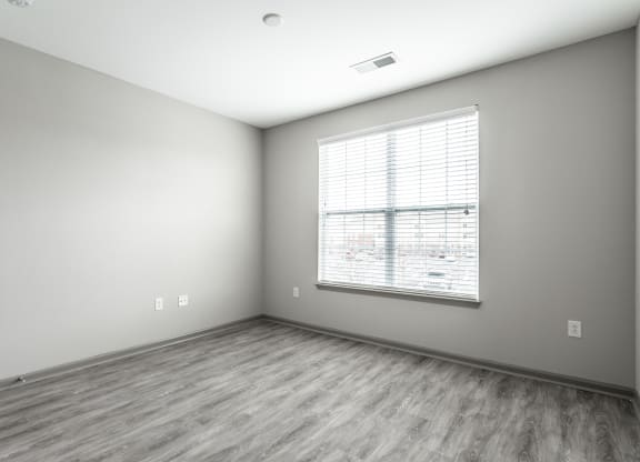 an empty room with a large window and wood floorsat Bella Vista Apartments, Fishers 46038