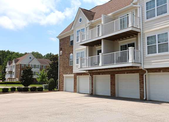 A large two-story house with a balcony and garage doors.