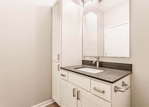 A bathroom with a sink and a mirror.
