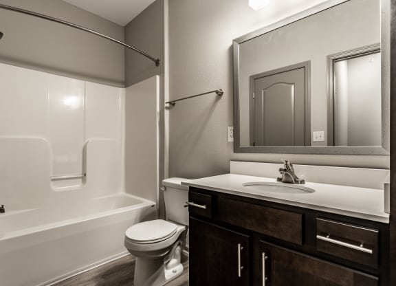 a bathroom with a shower sink and toilet and a mirror at Bella Vista Apartments, Fishers