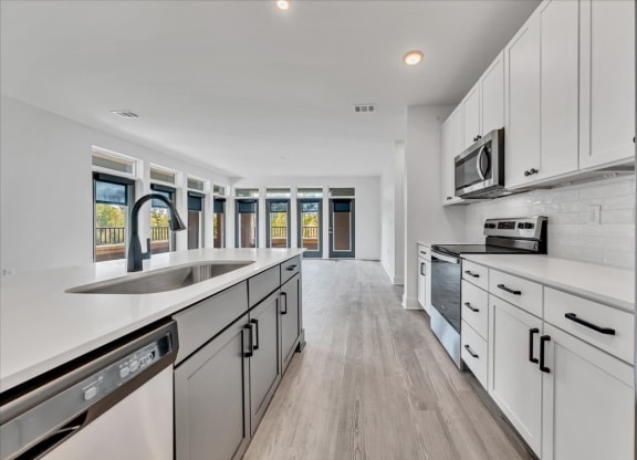 a large kitchen with white cabinets and a sink  at Luxe 360 on Centerpointe Apartments, Midlothian, VA, 23114