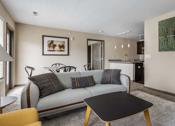 A living room with a grey couch and a black coffee table.