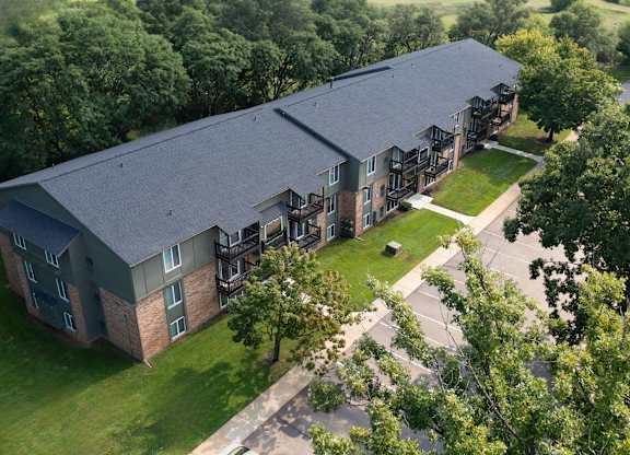 A large building with a grey roof and a green lawn in front