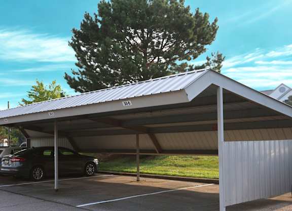 A carport with a metal roof and a car parked under it at The Harbours Apartments, Clinton Twp