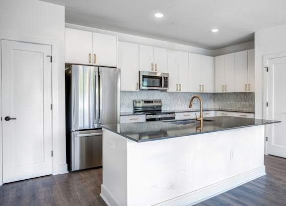 A modern kitchen with white cabinets and a central island.