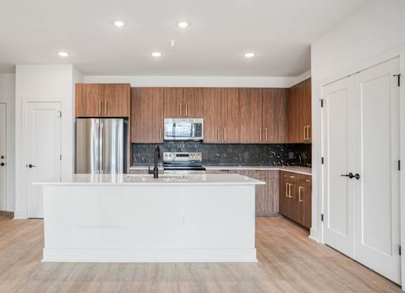 A modern kitchen with wooden cabinets and a white island.
