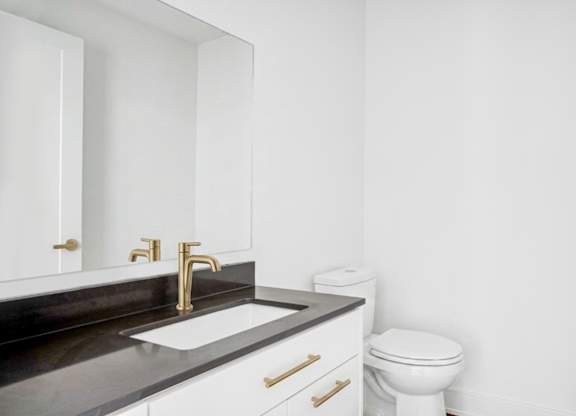 A white toilet sits next to a sink in a bathroom.