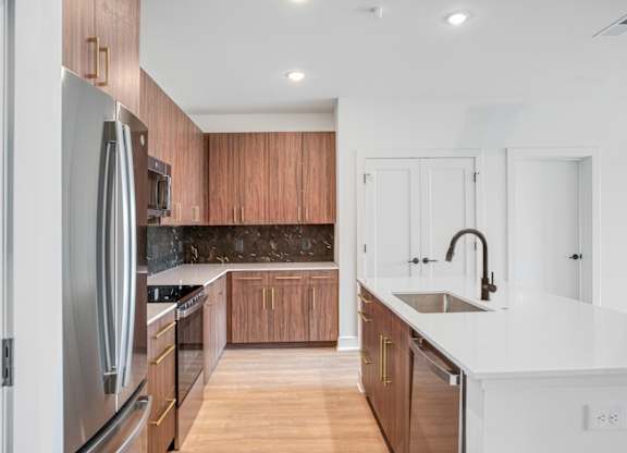 A modern kitchen with wooden cabinets and stainless steel appliances.