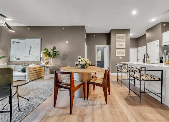 A modern dining room with a wooden table and chairs.