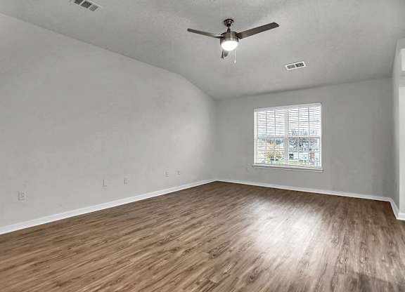 an empty living room with hardwood floors and a ceiling fan at Latitudes Apartments, Indianapolis, 46237