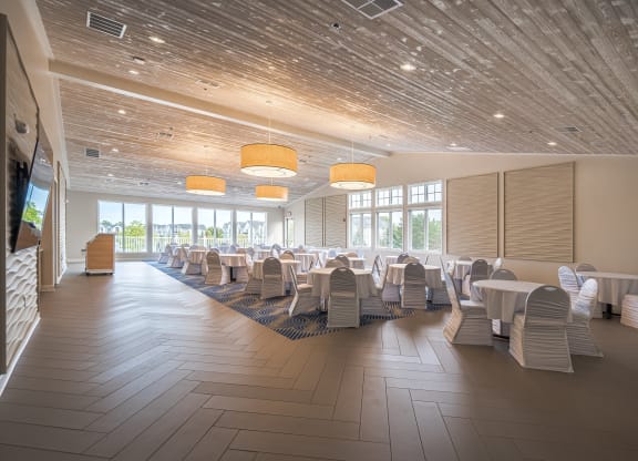 a large room with tables and chairsat The Harbours Apartments, Clinton Twp, MI, 48038