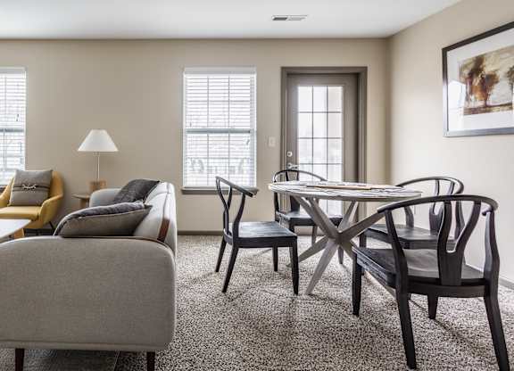 A living room with a grey sofa, a wooden coffee table, and a black chair.