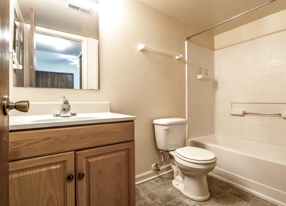 a bathroom with a toilet and a sink and a bath tub at Bay Pointe Apartments in Indiana 47909