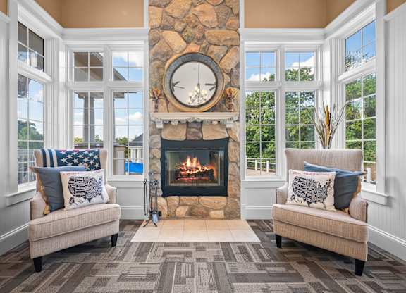 A cozy living room with a fireplace and two couchesk at Timberlane Apartments, Peoria, Illinois